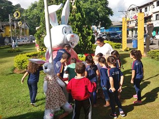 Meninos e meninas escolares brincam com os coelhinhos em Marechal Floriano