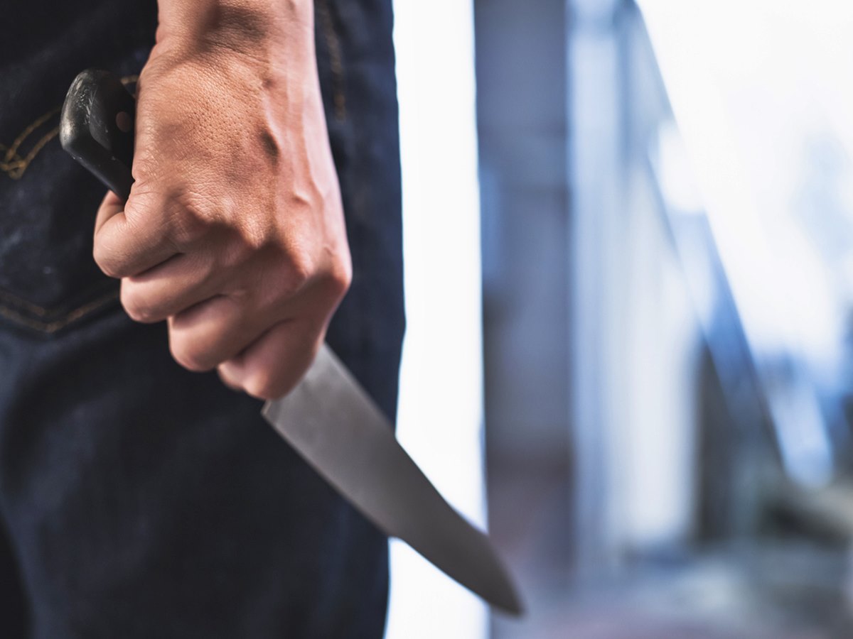 image of a robbers hands holding a knife in the shadows. image of a robbers hands holding a knife in the shadows.