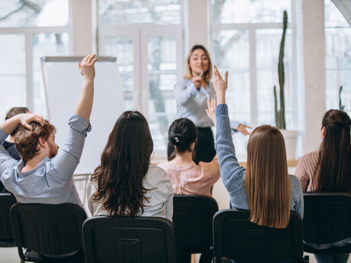 Female speaker giving presentation in hall at workshop. Audience or conference hall. Rear view of unrecognized participants. Increase. Female speaker giving presentation in hall at university workshop. Audience or conference hall. Rear view of unrecognized participants. Scientific, business event, training. Education