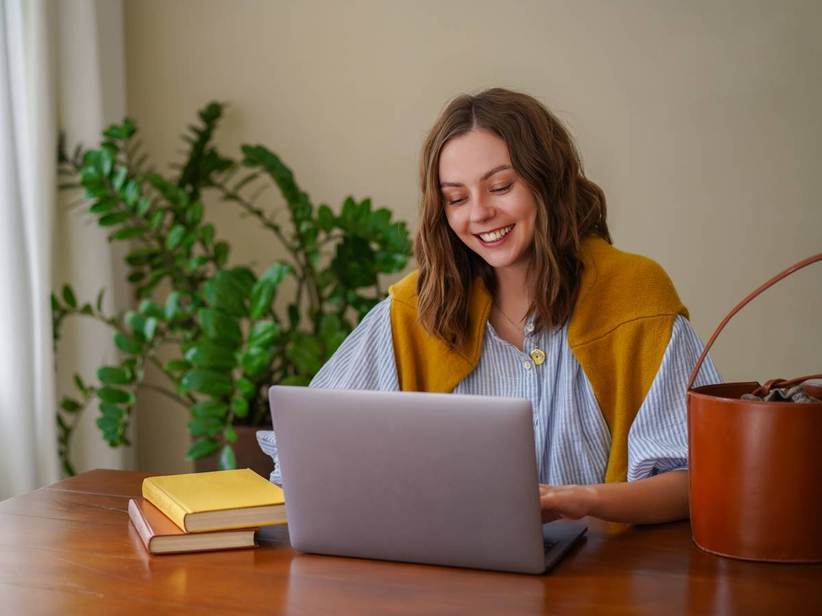 StudyBay Pretty woman working at her home office, smiling end enjoying time at her living room.