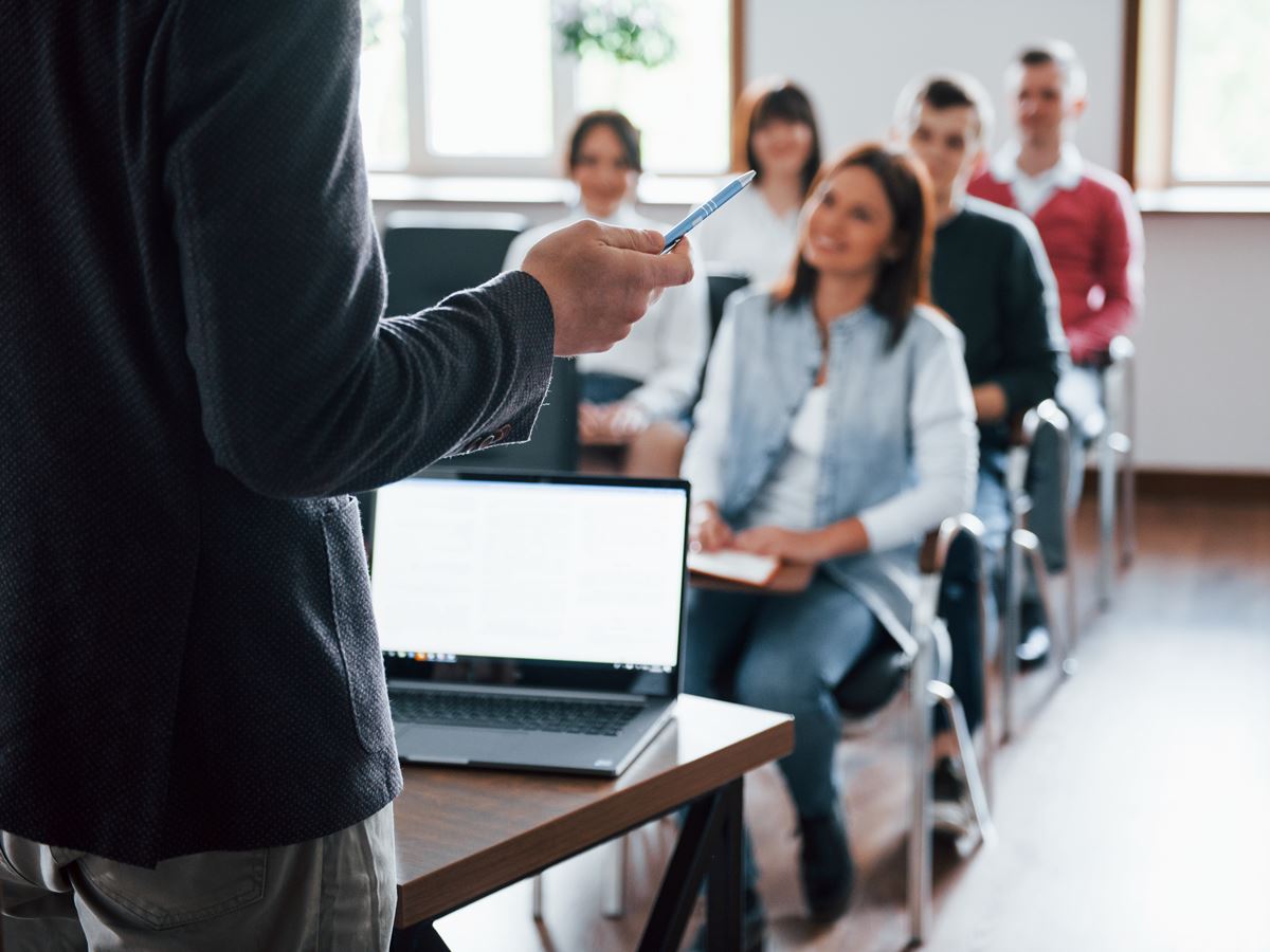 Everyone is smiling and listens. Group of people at business conference in modern classroom at daytime Everyone is smiling and listens. Group of people at business conference in modern classroom at daytime.