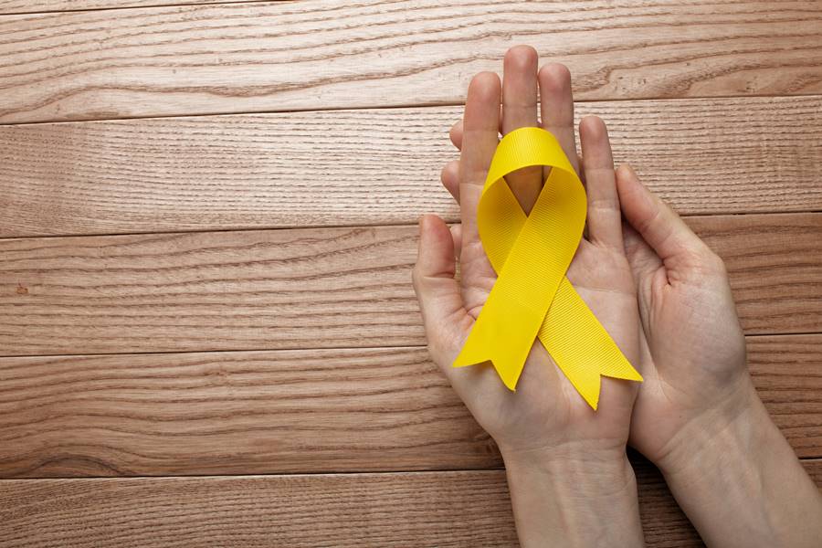 vista-da-fita-amarela-com-maos-humanas-em-fundo-de-madeira