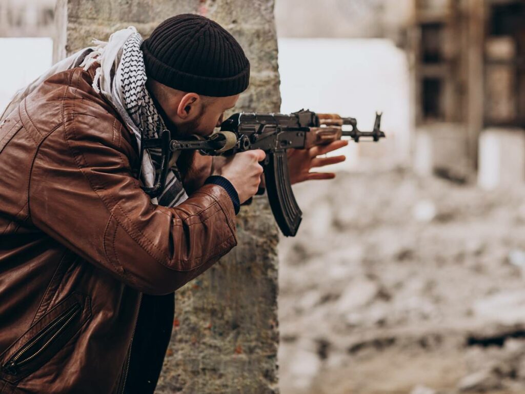 Terrorist with gun fighting with soldiers