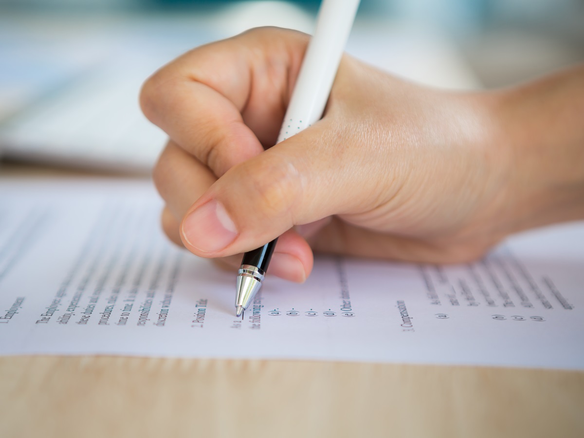 Close up of hand completing an employment application form Close up of hand completing an employment application form