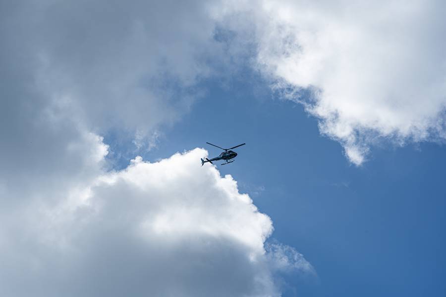 A low angle shot of a helicopter in the cloudy sky