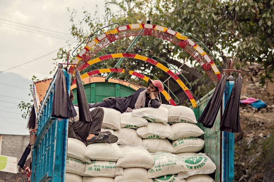 Pakistani man in the truck travelling on the bags with sugar in Northern Pakistan