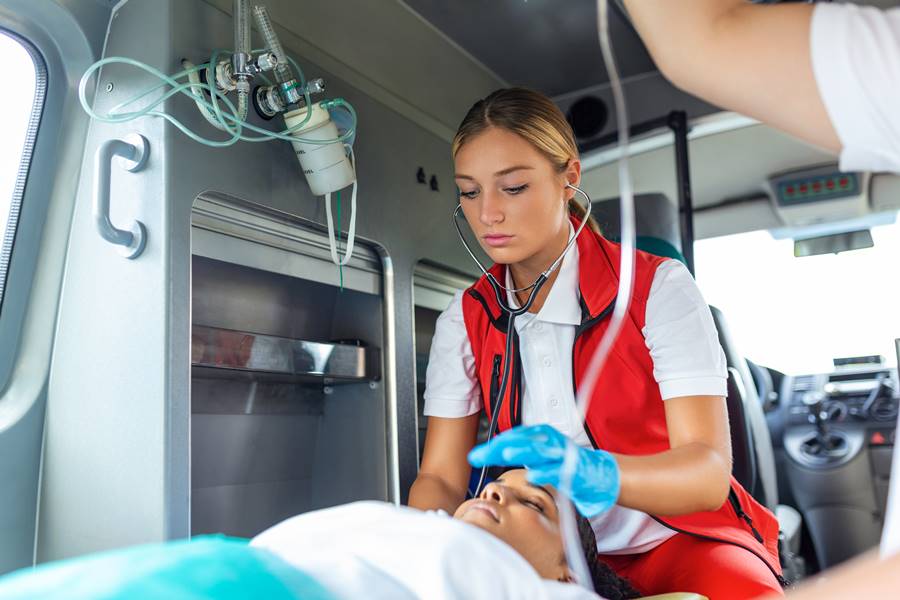 Doctors emergency or paramedics are working with a senior woman patient while he lies on a stretcher in an ambulance. Doctors emergency or paramedics are working with a senior woman patient while he lies on a stretcher in an ambulance.