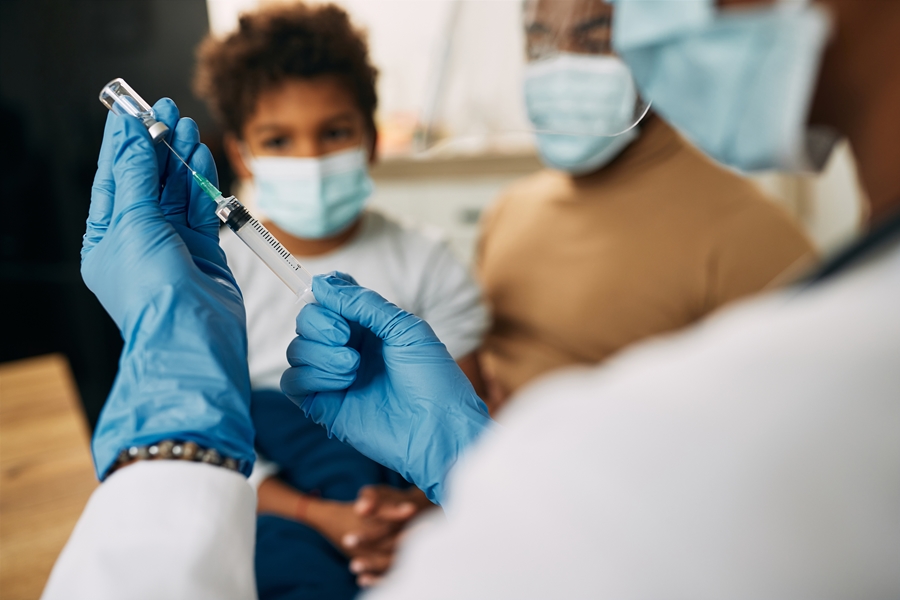 Close-up of a pediatrician preparing vaccine for a child. Close-up of a doctor using syringe and preparing medicine for a child during coronavirus pandemic.