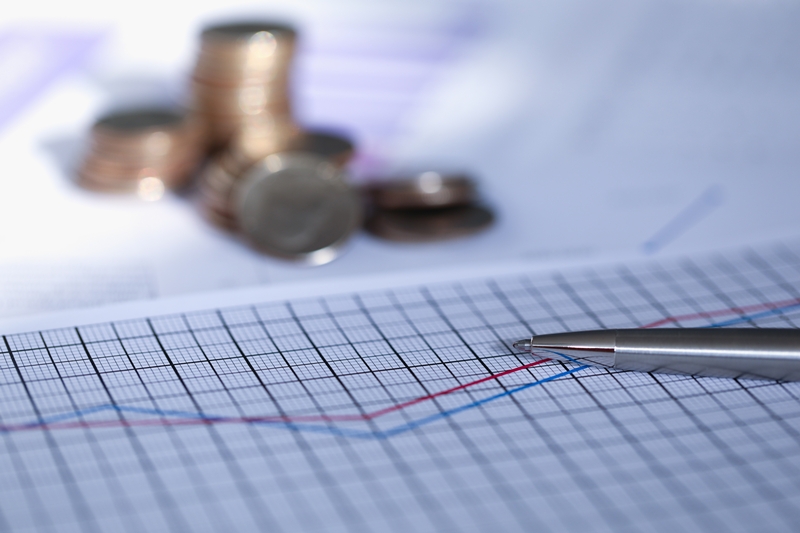 Silver pen lies on report with graph next to coin Silver pen lies on report with graph next to coin. Scaling business helps capture market and dictate terms, which affects profit. Increasing sales, opening branches, creating franchise