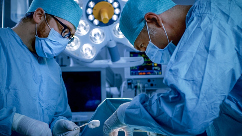 In the Hospital Operating Room Diverse Team of Professional Surgeons and Nurses Suture Wound after Successful Surgery.