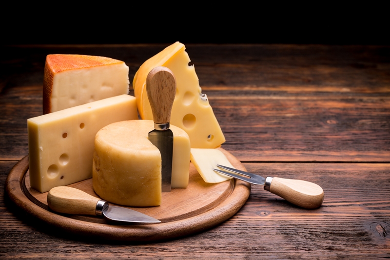 Various types of cheese on wooden board