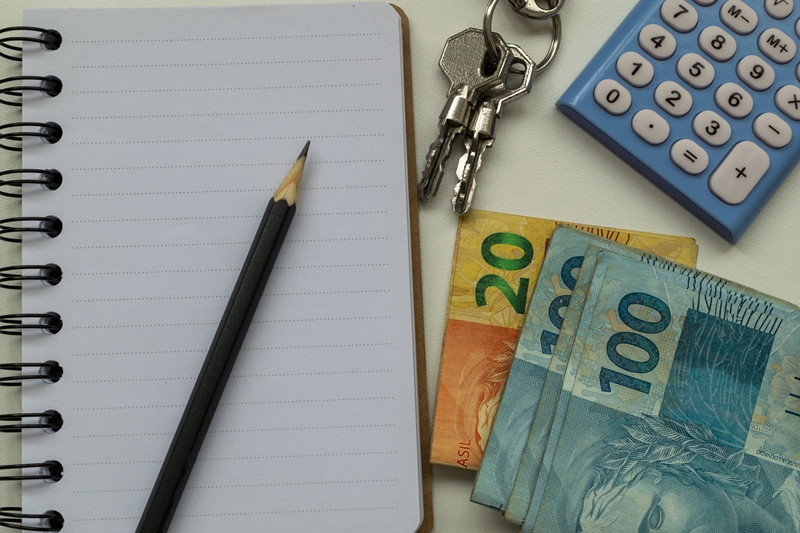 Property rental planning. Brazilian money, calculator, notepad, pencil and keys.