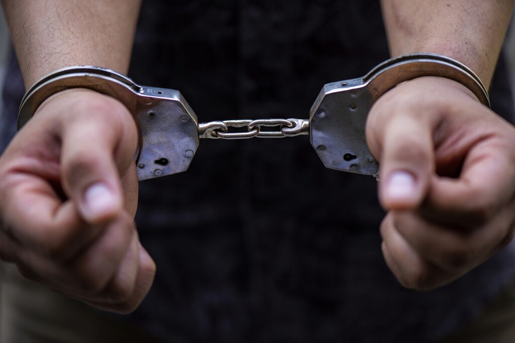 Man's hand is locked with the handcuffs