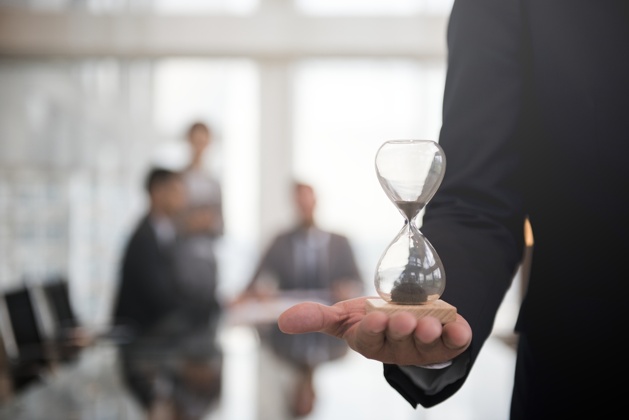 Businessman holding an hour glass, signifies the importance of being on time
