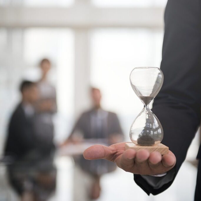 Businessman holding an hour glass, signifies the importance of being on time