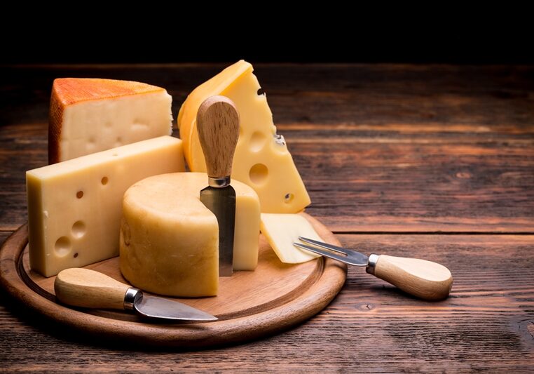 Various types of cheese on wooden board