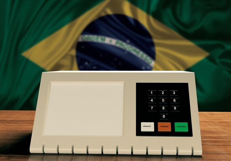 Electronic ballot box used in Brazil elections with Brazilian flag in the background. 3D rendering