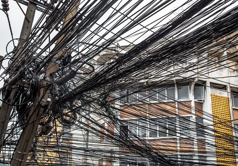 Messy wires attached to the electric pole, the chaos of cables and wires on an electric pole in Bangkok, Thailand, concept of electricity