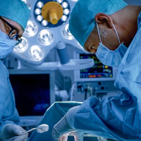 In the Hospital Operating Room Diverse Team of Professional Surgeons and Nurses Suture Wound after Successful Surgery.