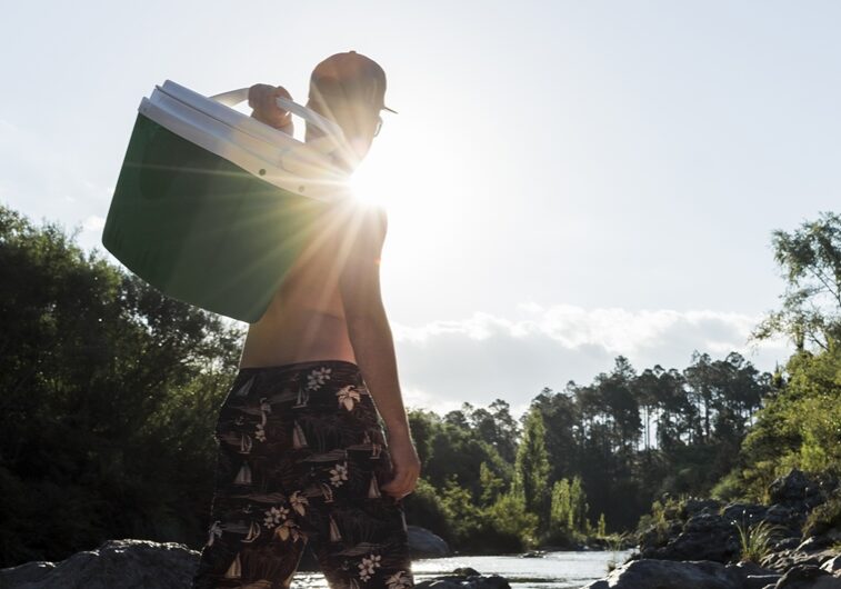 male-with-cool-box-sand-coast-near-river
