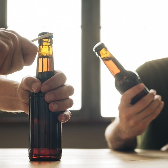 man-looking-person-opening-brown-beer-bottle-restaurant (1)