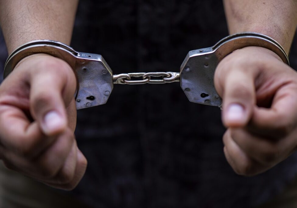 Man's hand is locked with the handcuffs