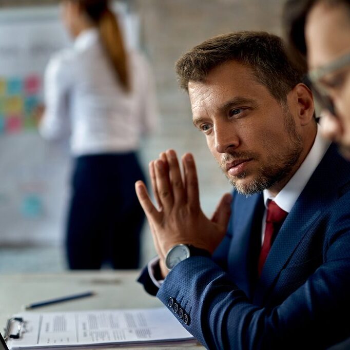 Mid adult businessman using computer while working with a colleague in the office.