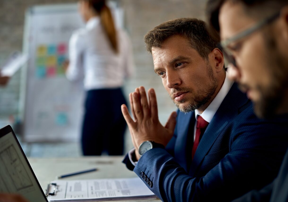 Mid adult businessman using computer while working with a colleague in the office.