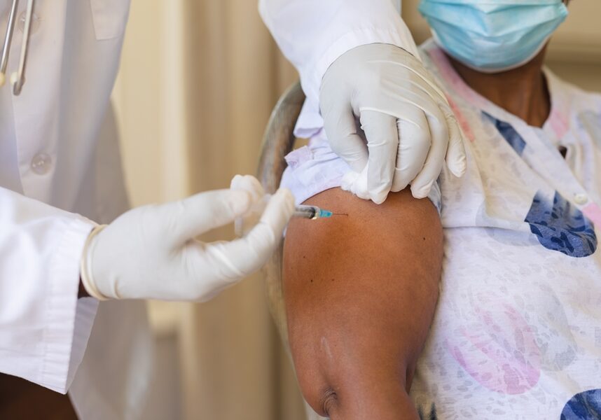 Senior african american woman in face mask receiving vaccination. retirement and senior lifestyle during covid 19 pandemic concept.